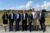 Sieben Personen stehen zum Gruppenbild zusammen vor einer Wiese.