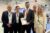 5 Personen stehen zum Gruppenbild auf der INTERGEO zusammen. In der MItte ist Staatssekretär Sebastian Wüste zu sehen, der ein Prospekt in der Hand hält.